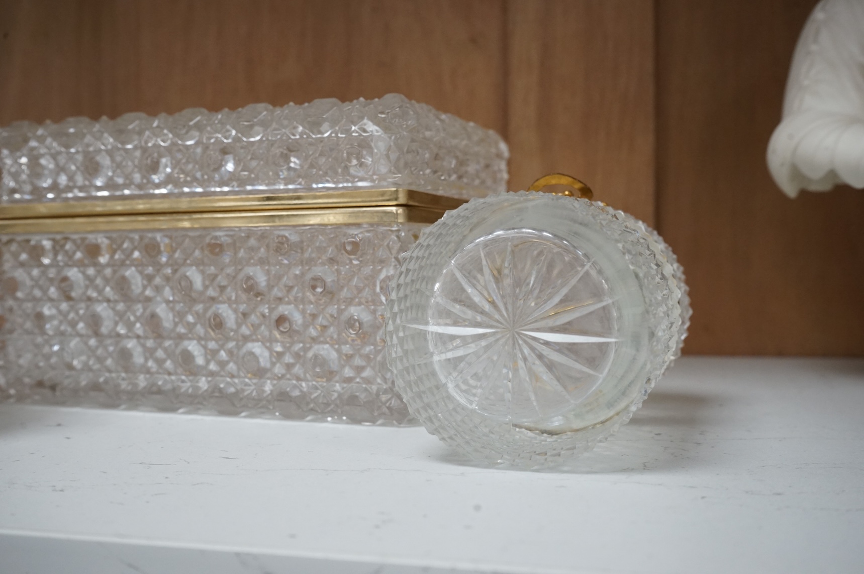 A deeply cut rectangular glass casket, a similar smaller casket and a cylindrical container, all with gilt metal mounts, largest 18cm wide x 10.5cm high.